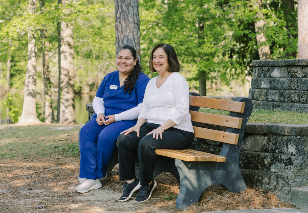 DayBreak caregiver sitting with an older adult client outdoors