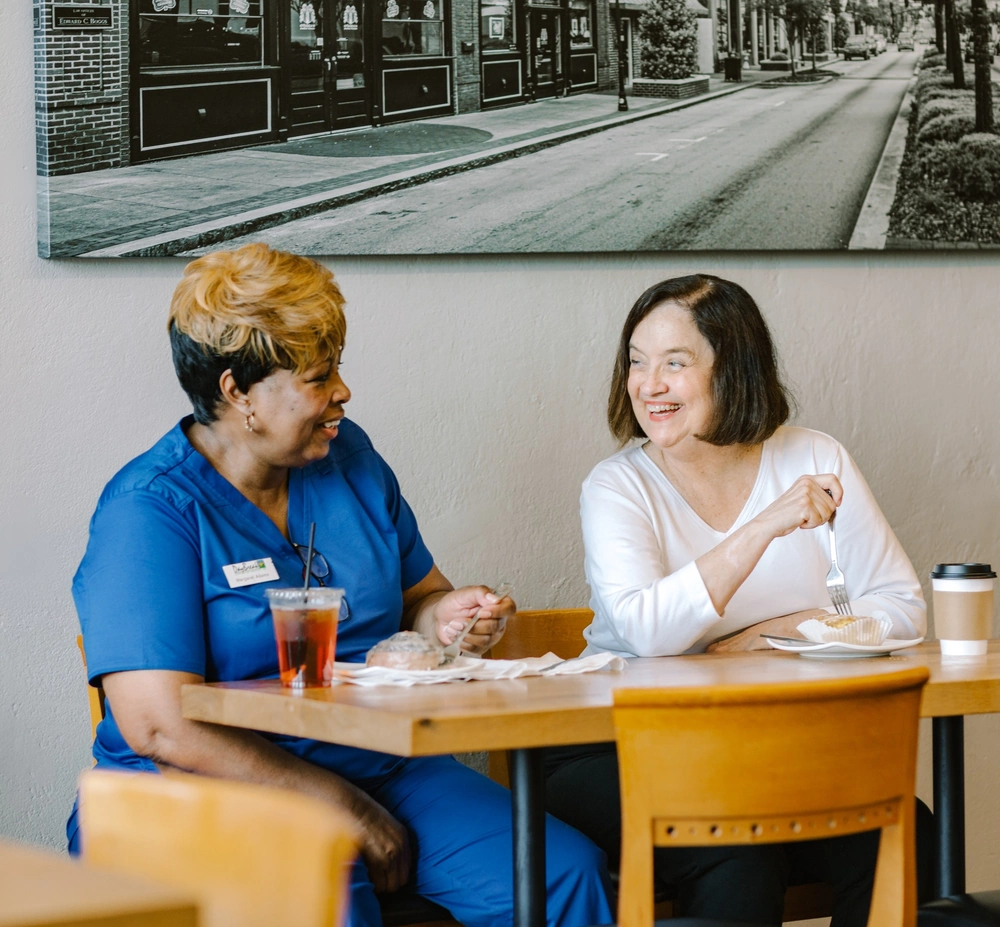 DayBreak caregiver sharing a meal and conversation with an adult client