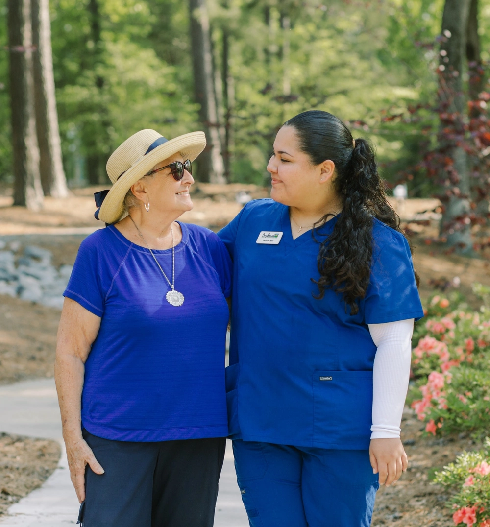 DayBreak caregiver walking outdoors with an older adult client