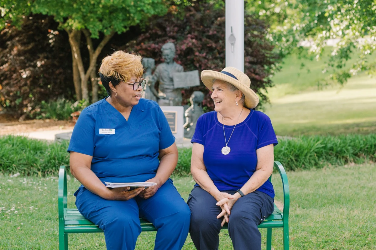 DayBreak caregiver and older adult talking together on a park bench