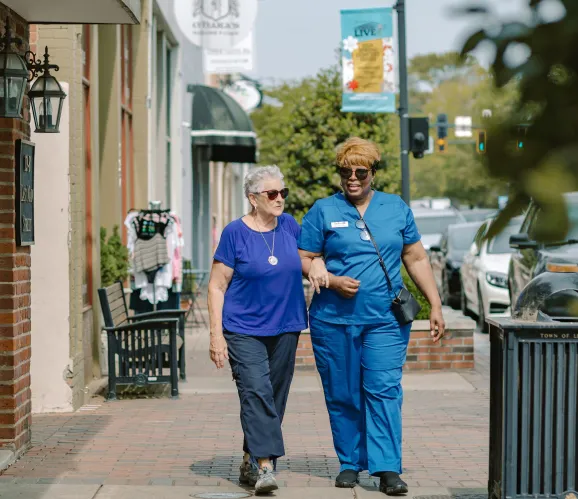 A DayBreak caregiver walking with an older adult
