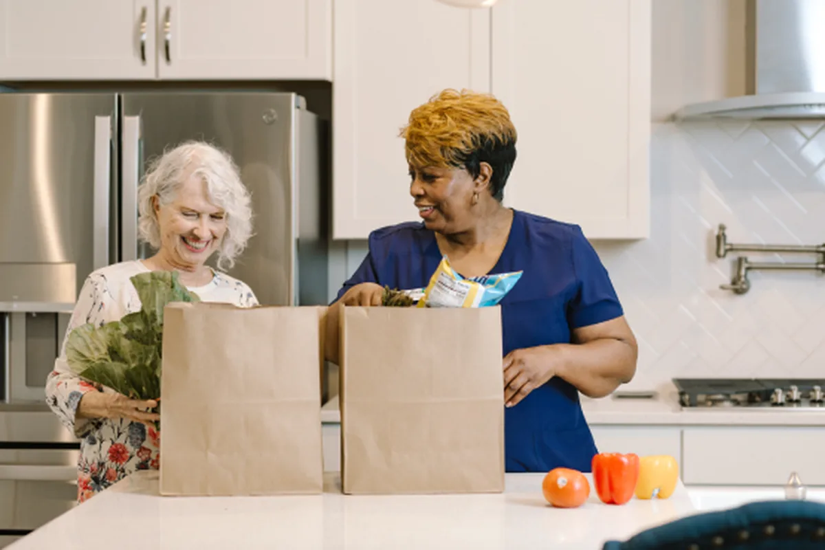 DayBreak caregiver helping an older adult with groceries and everyday tasks at home